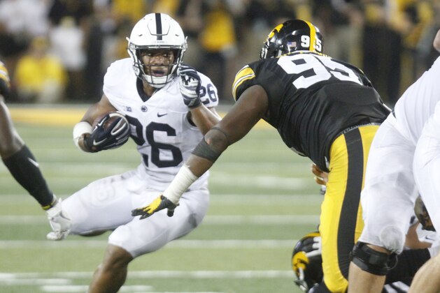 IOWA CITY, IOWA- SEPTEMBER 23:  Running back Saquon Barkley #26 of the Penn State Nittany Lions rushes up field during the third quarter past defensive lineman Cedrick Lattimore #95 of the Iowa Hawkeyes on September 23, 2017 at Kinnick Stadium in Iowa City, Iowa.  (Photo by Matthew Holst/Getty Images)