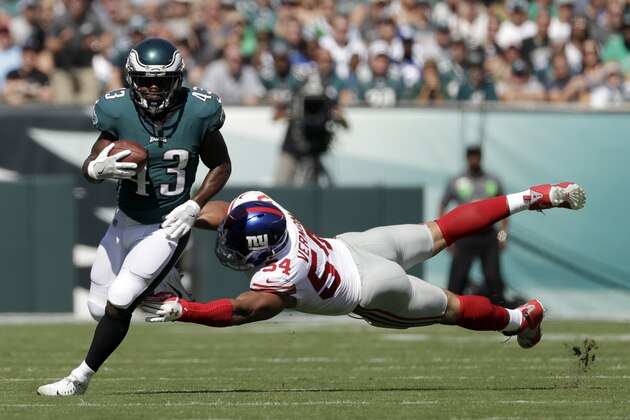 Philadelphia Eagles' Darren Sproles, left, tries to slip past New York Giants' Olivier Vernon during the first half of an NFL football game, Sunday, Sept. 24, 2017, in Philadelphia. (AP Photo/Michael Perez)
