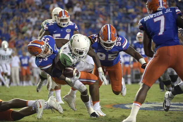 North Texas running back Jeffrey Wilson (26) is tackled by Florida linebacker David Reese (33) and defensive lineman Keivonnis Davis (95) after rushing for yardage during the second half of an NCAA college football game in Gainesville, Fla., Saturday, Sept. 17, 2016. Florida won 32-0. (AP Photo/Phelan M. Ebenhack)
