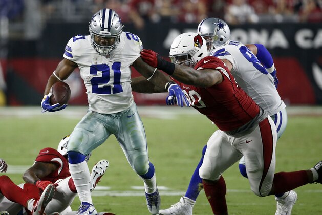 Dallas Cowboys running back Ezekiel Elliott (21) runs as Arizona Cardinals defensive tackle Robert Nkemdiche (90) misses the tackle during the second half of an NFL football game, Monday, Sept. 25, 2017, in Glendale, Ariz. (AP Photo/Ross D. Franklin)