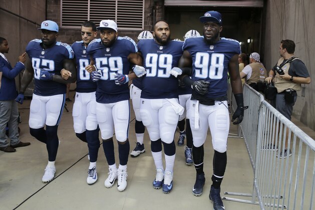 Tennessee Titans players walk to the field with arms linked after the national anthem had been played before an NFL football game between the Titans and the Seattle Seahawks Sunday, Sept. 24, 2017, in Nashville, Tenn. Neither team stood on the field for the anthem. From left are Delanie Walker (82), Marcus Mariota (8), Wesley Woodyard (59), Jurrell Casey (99) and Brian Orakpo (98). (AP Photo/James Kenney)