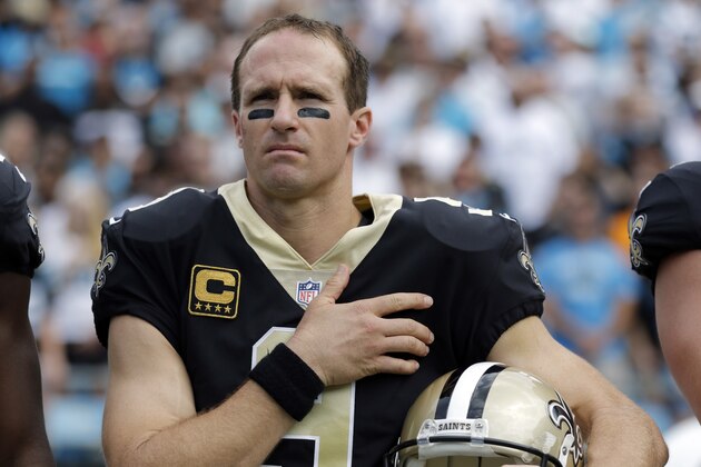 New Orleans Saints quarterback Drew Brees (9) stands with his hand over his heart during the national anthem before an NFL football game against the Carolina Panthers in Charlotte, N.C., Sunday, Sept. 24, 2017. Several Saints players sat on the bench during the anthem. (AP Photo/Bob Leverone)