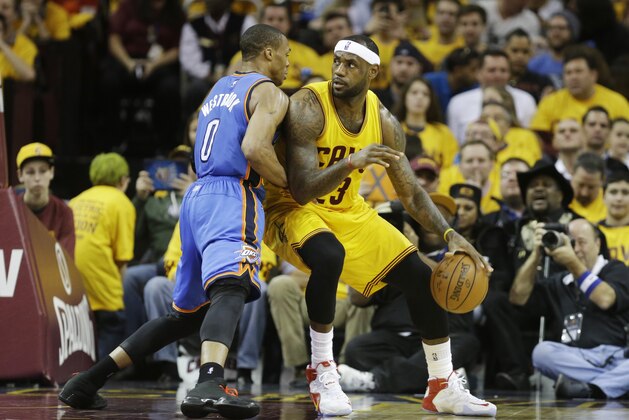 Cleveland Cavaliers' LeBron James backs in against Oklahoma City Thunder's Russell Westbrook (0) in an NBA basketball game Sunday, Jan. 25, 2015, in Cleveland. (AP Photo/Mark Duncan)