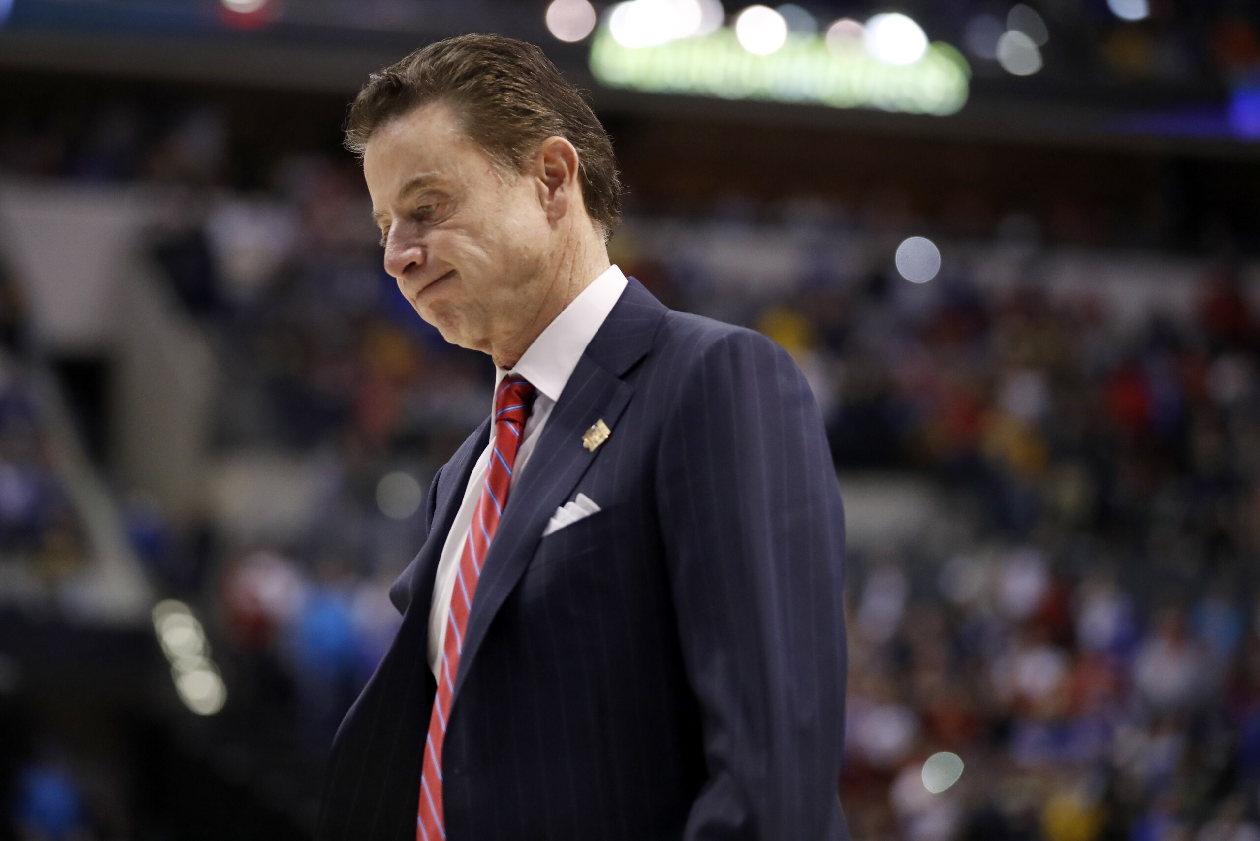 FILE - In this Sunday, March 19, 2017, file photo, Louisville head coach Rick Pitino walks off the court after a 73-69 loss to Michigan in a second-round game in the men's NCAA college basketball tournament in Indianapolis. The NCAA is standing by its allegations against the Louisville men's basketball program and Pitino, saying the coach failed to notice