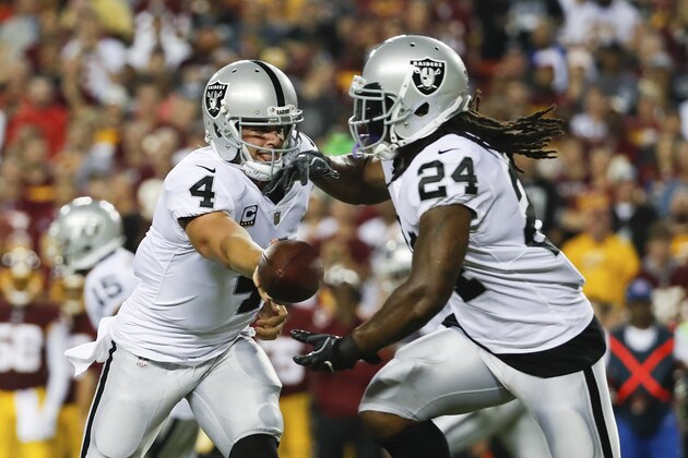 Oakland Raiders quarterback Derek Carr (4) hands the ball to running back Marshawn Lynch (24) during the first half of an NFL football game against the XXX in Landover, Md., Sunday, Sept. 24, 2017. (AP Photo/Alex Brandon)