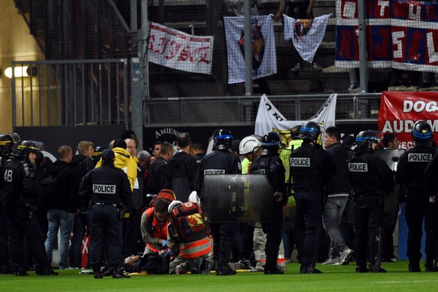 French police officers and members of the stadium staff stand by rescuers as they take care of wounded LOSC' supporters following the fall of their tribune during the French L1 football match between Amiens and Lille LOSC on September 30, 2017 at the Licorne stadium in Amiens. / AFP PHOTO / FRANCOIS LO PRESTI        (Photo credit should read FRANCOIS LO PRESTI/AFP/Getty Images)