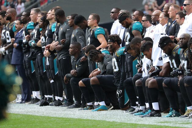 LONDON, ENGLAND - SEPTEMBER 24: Jacksonville Jaguars Owner Shahid Kahn links arms with his team as some players take a knee during the National Anthem during the NFL match between the Jacksonville Jaguars and the Baltimore Ravens at Wembley Stadium on September 24, 2017 in London, United Kingdom. (Photo by Mitchell Gunn/Getty Images)