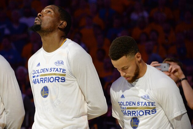 OAKLAND, CA - JUNE 12:  Kevin Durant #35 and Stephen Curry #30 of the Golden State Warriors during the national anthem before the game against the Cleveland Cavaliers in Game Five of the 2017 NBA Finals on June 12, 2017 at ORACLE Arena in Oakland, California. NOTE TO USER: User expressly acknowledges and agrees that, by downloading and/or using this photograph, user is consenting to the terms and conditions of Getty Images License Agreement. Mandatory Copyright Notice: Copyright 2017 NBAE (Photo by Andrew D. Bernstein/NBAE via Getty Images)