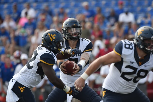 LAWRENCE, KS - SEPTEMBER 23: Will Grier #7 of the West Virginia Mountaineers hands the ball of to Martell Pettaway #32 against the Kansas Jayhawks at Memorial Stadium on September 23, 2017 in Lawrence, Kansas. (Photo by Ed Zurga/Getty Images)