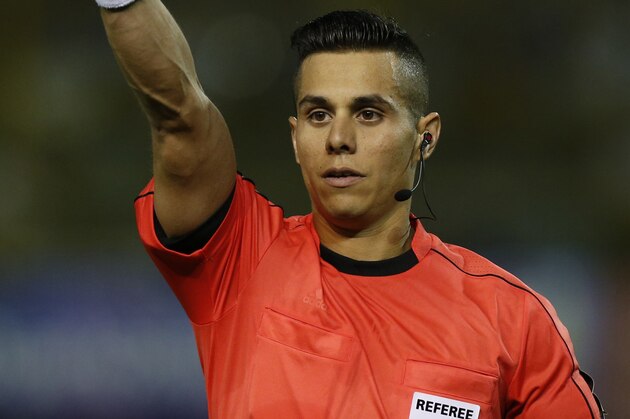 Referee Armando Villarreal from US shows a yellow card to El Salvador's Jaime Alas during a 2018 World Cup qualifier soccer match against Mexico in San Salvador, El Salvador, Friday, Sept. 2, 2016. (AP Photo/Moises Castillo)