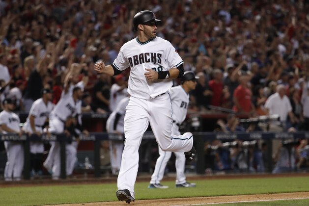 Arizona Diamondbacks' J.D. Martinez (28) scores on a two-RBI triple by teammate A.J. Pollock during the eighth inning of the National League wild-card playoff baseball game against the Colorado Rockies, Wednesday, Oct. 4, 2017, in Phoenix. (AP Photo/Matt York)