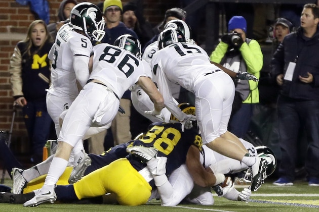FILE - In this Oct. 17, 2015, file photo, Michigan State defensive back Jalen Watts-Jackson, lower right, falls into the end zone after recovering a fumbled snap on a punt in the closing seconds of the second half of an NCAA college football game in Ann Arbor, Mich. Michigan punter Blake O'Neill fumbled the snap and Watts-Jackson pulled it in, cradled it to his body and ran 38 yards for a touchdown. (AP Photo/Carlos Osorio, File)