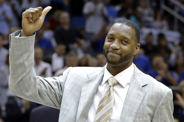 FILe - In this Nov. 1, 2013, file phioto, former Orlando Magic player Tracy McGrady gives the thumbs up to fans as he was honored in a ceremony commemorating the Magic's 25th season during the first half of an NBA basketball game against the New Orleans Pelicans,  in Orlando, Fla.  Former All-Star Tracy McGrady is joining ESPN as an analyst and will make regular appearances on its new daily NBA show. (AP Photo/John Raoux, File)