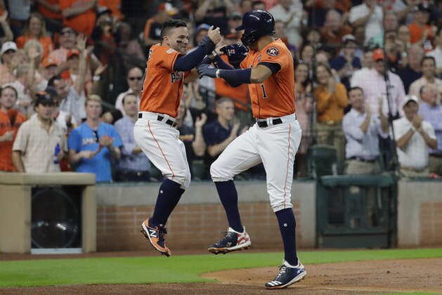 Houston Astros' Carlos Correa, right, celebrates his two-run home run with teammate Jose Altuve, left, during the first inning in Game 2 of baseball's American League Division Series against the Boston Red Sox, Friday, Oct. 6, 2017, in Houston. (AP Photo/David J. Phillip)