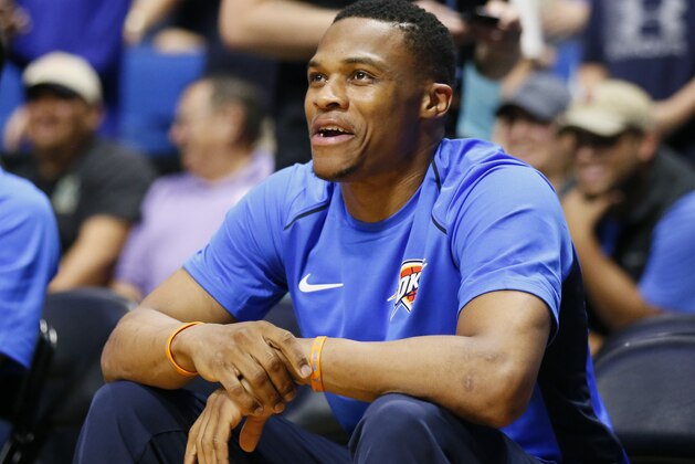 Oklahoma City Thunder guard Russell Westbrook smiles on the bench during before the team's NBA preseason basketball game against the Houston Rockets in Tulsa, Okla., Tuesday, Oct. 3, 2017. (AP Photo/Sue Ogrocki)