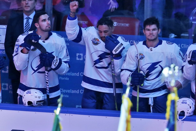 Tampa Bay Lightning right wing J.T. Brown, center, raises his fist in the air during the singing of the national nnthem before the start of an NHL hockey game between the Florida Panthers and the Tampa Bay Lightning, Saturday, Oct. 7, 2017, in Sunrise, Fla. (AP Photo/Wilfredo Lee),