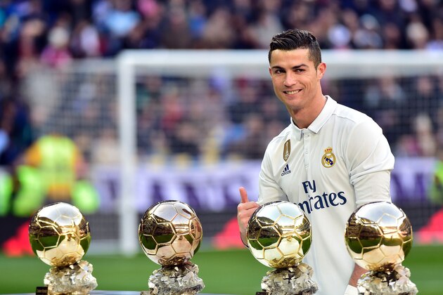 TOPSHOT - Real Madrid's Portuguese forward Cristiano Ronaldo poses with his four Ballon d'Or France Football trophies before the Spanish league football match Real Madrid CF vs Granada FC at the Santiago Bernabeu stadium in Madrid on January 7, 2017. / AFP / GERARD JULIEN        (Photo credit should read GERARD JULIEN/AFP/Getty Images)