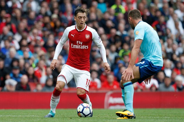 Arsenal's German midfielder Mesut Ozil (L) takes on Bournemouth's English defender Steve Cook (R) during the English Premier League football match between Arsenal and Bournemouth at the Emirates Stadium in London on September 9, 2017. / AFP PHOTO / Ian KINGTON / RESTRICTED TO EDITORIAL USE. No use with unauthorized audio, video, data, fixture lists, club/league logos or 'live' services. Online in-match use limited to 75 images, no video emulation. No use in betting, games or single club/league/player publications.  /         (Photo credit should read IAN KINGTON/AFP/Getty Images)
