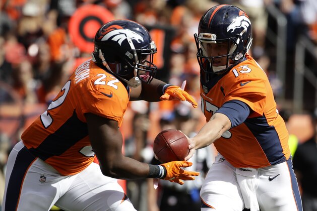 Denver Broncos quarterback Trevor Siemian, right, hands off to running back C.J. Anderson during the first half of an NFL football game against the Oakland Raiders Sunday, Oct. 1, 2017, in Denver. (AP Photo/Jack Dempsey)