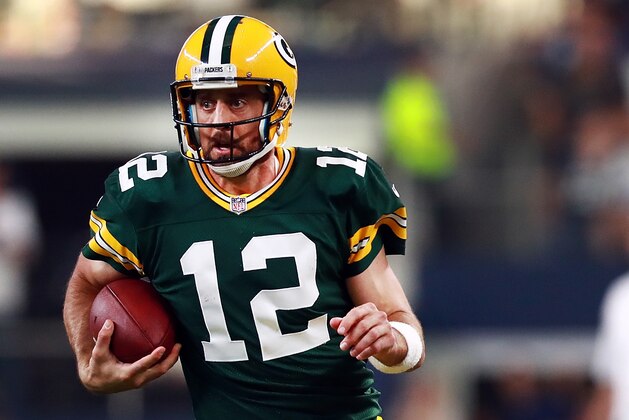 ARLINGTON, TX - OCTOBER 08:  Aaron Rodgers #12 of the Green Bay Packers scrambles with the ball against David Irving #95 of the Dallas Cowboys in the fourth quarter at AT&T Stadium on October 8, 2017 in Arlington, Texas.  (Photo by Tom Pennington/Getty Images)