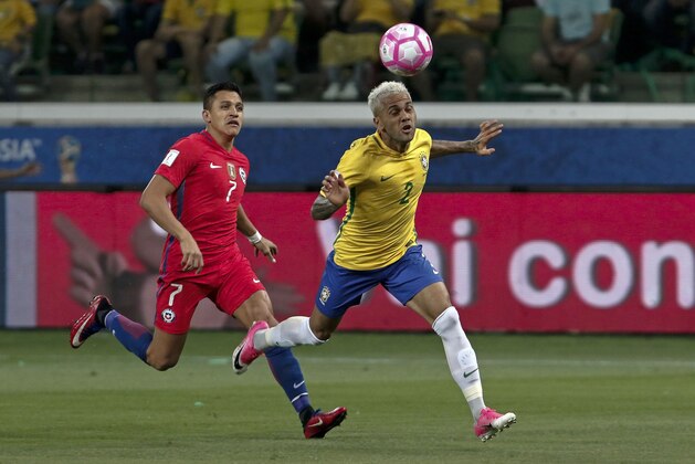 Brazil's Dani Alves (R) and Chile's Alexis Sanchez vie for the ball during their FIFA 2018 World Cup qualifier football match in Sao Paulo, Brazil, on October 10, 2017. / AFP PHOTO / Miguel SCHINCARIOL        (Photo credit should read MIGUEL SCHINCARIOL/AFP/Getty Images)