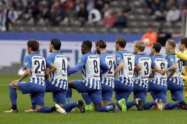 Players of Berlin kneel down prior to the German Bundesliga soccer match between Hertha BSC Berlin and FC Schalke 04 in Berlin, Germany, Saturday, Oct. 14, 2017. Hertha Berlin nodded to social struggles in the United States by kneeling before its Bundesliga game at home to Schalke on Saturday. Hertha’s starting lineup linked arms and took a knee on the pitch, while coaching staff, officials and substitutes took a knee off it. The action was intended to show solidarity with NFL players who have been demonstrating against discrimination in the US by kneeling, sitting or locking arms through the anthem before games.  (AP Photo/Michael Sohn)