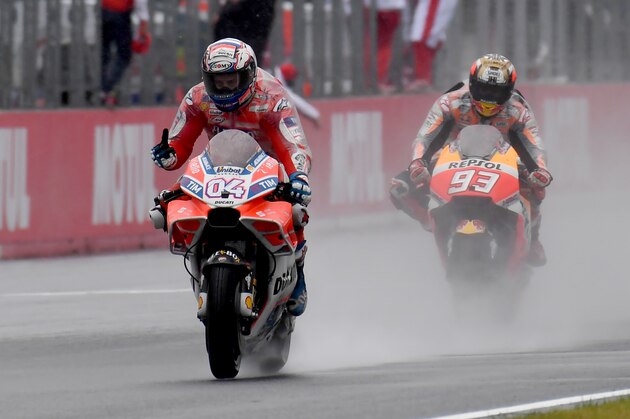 Ducati rider Andrea Dovizioso of Italy (L) flashes thumb-up while receiving a checkered flag ahead of Honda rider Marc Marquez of Spain (R) during the MotoGP Japanese Grand Prix at Twin Ring Motegi circuit in Motegi, Tochigi prefecture on October 15, 2017. / AFP PHOTO / TOSHIFUMI KITAMURA        (Photo credit should read TOSHIFUMI KITAMURA/AFP/Getty Images)