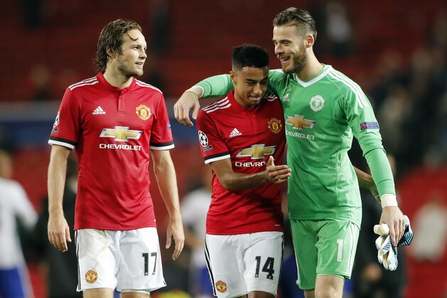 Manchester United goalkeeper David de Gea, right, embraces Manchester United's Jesse Lingard, center as Manchester United's Daley Blind looks on, at the end of the Champions League group A soccer match between Manchester United and Basel, at the Old Trafford stadium in Manchester, Tuesday, Sept. 12, 2017. (AP Photo/Frank Augstein)