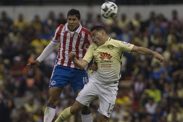 America's Pablo Aguilar, right, heads for the ball past Chivas' Angel Zaldivar during a Mexican soccer league match in Mexico City, Saturday, Aug. 27, 2016. Chivas won the match 3-0. (AP Photo/Christian Palma)