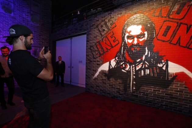 WWE 2K18 Cover Superstar Seth Rollins takes a photo of a mural painted of him seen at the WWE 2K18 SummerSlam Kickoff Event on Friday, Aug. 18, 2017, in New York. (Photo by Adam Hunger/Invision for 2K Games/AP Images)