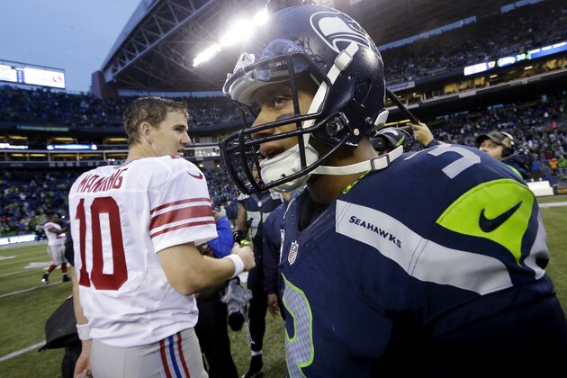 Seattle Seahawks quarterback Russell Wilson, right, turns away after greeting New York Giants quarterback Eli Manning after an NFL football game, Sunday, Nov. 9, 2014, in Seattle. The Seahawks won 38-17. (AP Photo/Elaine Thompson)