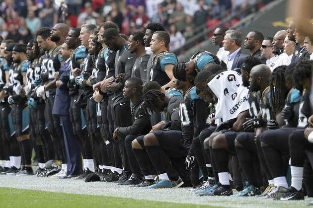 FILE - In this Sept. 24, 2017, file photo, Jacksonville Jaguars NFL football players are shown, some standing an some kneeling, during the playing of the national anthem before an NFL football game against the Baltimore Ravens at Wembley Stadium in London. The Jaguars have apologized to military leaders for demonstrating during the national anthem in London last month. Jaguars President Mark Lamping sent a letter to the director of military affairs and veterans in Jacksonville saying the team was “remiss in not fully comprehending the effect of the national anthem demonstration on foreign soil has had on the men and women who have or continue to serve out country.”(AP Photo/Tim Ireland, File)