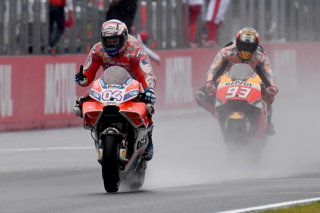 Ducati rider Andrea Dovizioso of Italy (L) flashes thumb-up while receiving a checkered flag ahead of Honda rider Marc Marquez of Spain (R) during the MotoGP Japanese Grand Prix at Twin Ring Motegi circuit in Motegi, Tochigi prefecture on October 15, 2017. / AFP PHOTO / TOSHIFUMI KITAMURA        (Photo credit should read TOSHIFUMI KITAMURA/AFP/Getty Images)