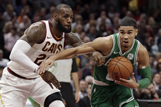 Boston Celtics' Jayson Tatum, right, drives past Cleveland Cavaliers' LeBron James in the first half of an NBA basketball game, Tuesday, Oct. 17, 2017, in Cleveland. (AP Photo/Tony Dejak)