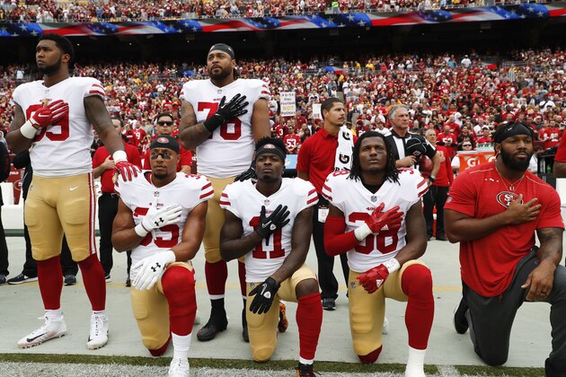 Member of the San Francisco 49ers kneel and stand during the playing of the National Anthem before an NFL football game against the Washington Redskins in Landover, Md., Sunday, Oct. 15, 2017. Kneeling are (L-R) strong safety Eric Reid (35), wide receiver Marquise Goodwin (11) and defensive back Adrian Colbert (38). (AP Photo/Alex Brandon)