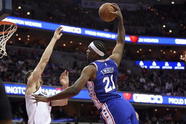 Philadelphia 76ers center Joel Embiid (21) goes to the basket against Washington Wizards forward Jason Smith, left, during the first half of an NBA basketball game, Wednesday, Oct. 18, 2017, in Washington. Smith was charged with a foul on the play.(AP Photo/Nick Wass)