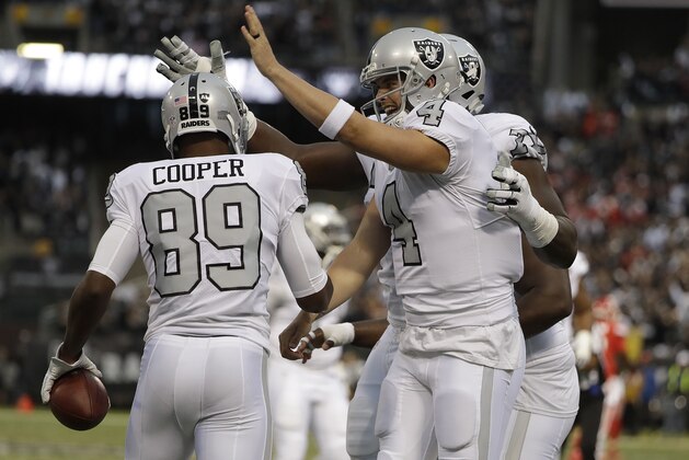 Oakland Raiders wide receiver Amari Cooper (89) and quarterback Derek Carr (4) celebrate after connecting on a touchdown pass against the Kansas City Chiefs during the first half of an NFL football game in Oakland, Calif., Thursday, Oct. 19, 2017. (AP Photo/Marcio Jose Sanchez)