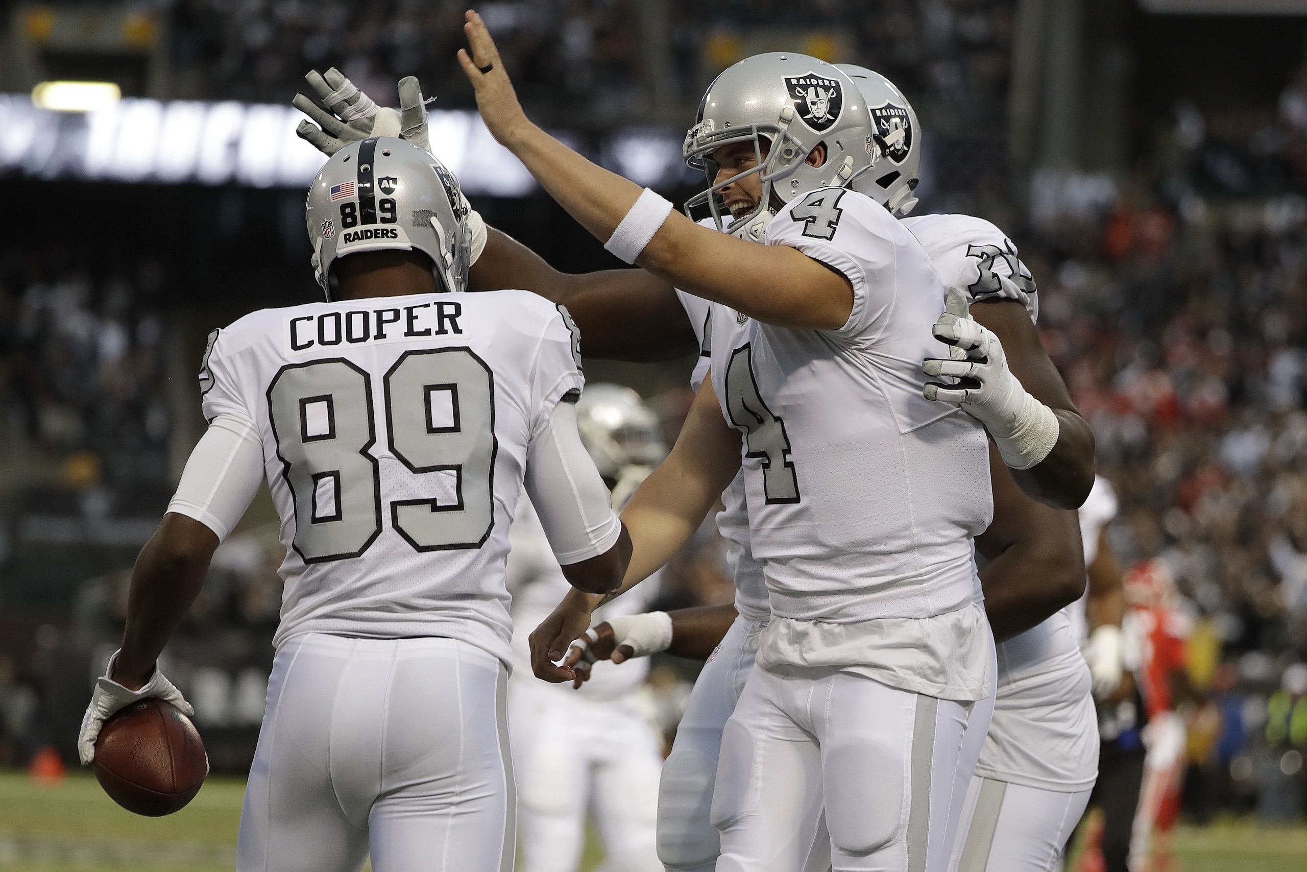 Oakland Raiders wide receiver Amari Cooper (89) and quarterback Derek Carr (4) celebrate after connecting on a touchdown pass against the Kansas City Chiefs during the first half of an NFL football game in Oakland, Calif., Thursday, Oct. 19, 2017. (AP Photo/Marcio Jose Sanchez)
