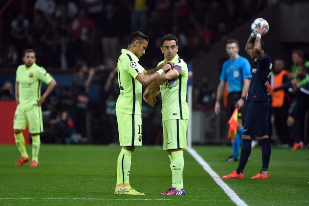 Barcelona's Brazilian forward Neymar da Silva Santos Junior (L) puts the captain armband on Barcelona's midfielder Xavi Hernandez during the UEFA Champions league quarter-final first leg football match PSG vs FC Barcelona at the Parc des Princes stadium in Paris on April 15, 2015.  AFP PHOTO / MARTIN BUREAU        (Photo credit should read MARTIN BUREAU/AFP/Getty Images)