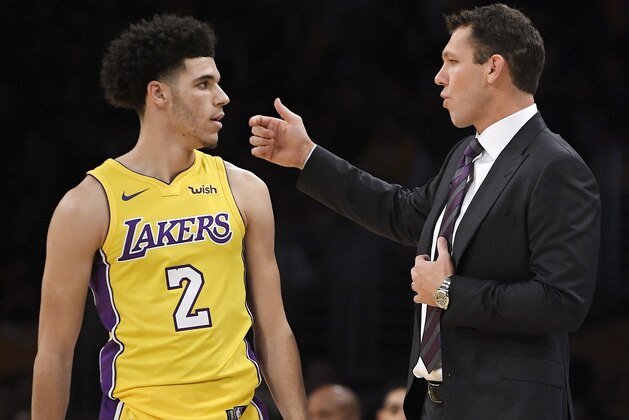 Los Angeles Lakers guard Lonzo Ball, left, talks with coach Luke Walton during the first half of an NBA basketball game against the Los Angeles Clippers, Thursday, Oct. 19, 2017, in Los Angeles. (AP Photo/Mark J. Terrill)