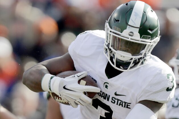 Michigan State running back LJ Scott (3) runs into Illinois' Hardy Nickerson during the first half of an NCAA college football game at Memorial Stadium Saturday, Nov. 5, 2016, in Champaign, Ill. (AP Photo/ Stephen Haas)