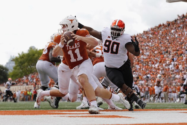 AUSTIN, TX - OCTOBER 21:  Sam Ehlinger #11 of the Texas Longhorns is forced to scramble under pressure by Taaj Bakari #90 of the Oklahoma State Cowboys in the second quarter at Darrell K Royal-Texas Memorial Stadium on October 21, 2017 in Austin, Texas.  (Photo by Tim Warner/Getty Images)