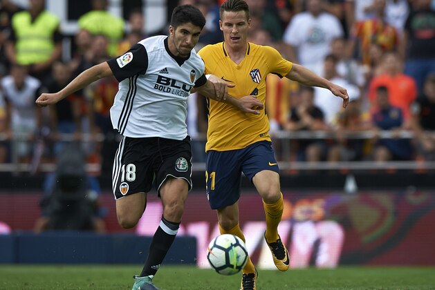 VALENCIA, SPAIN - SEPTEMBER 09:  Carlos Soler (L) of Valencia competes for the ball with Kevin Gameiro of Atletico Madrid during the La Liga match between Valencia CF and Atletico Madrid at Mestalla Stadium on September 9, 2017 in Valencia, Spain.  (Photo by fotopress/Getty Images)