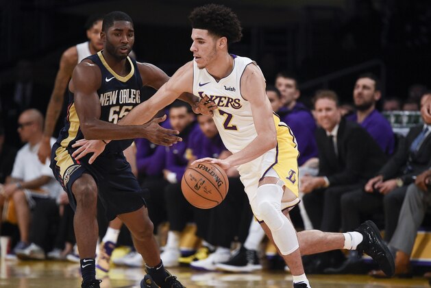Los Angeles Lakers guard Lonzo Ball, right, moves the ball around New Orleans Pelicans guard E'Twaun Moore during the first half of an NBA basketball game in Los Angeles, Sunday, Oct. 22, 2017. (AP Photo/Kelvin Kuo)