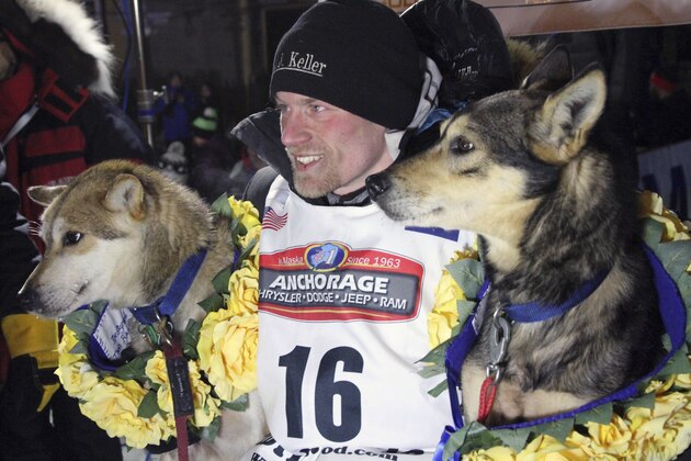 FILE - In this March 15, 2016, file photo, Dallas Seavey poses with his lead dogs Reef, left, and Tide after finishing the Iditarod Trail Sled Dog Race in Nome, Alaska. Seavey won his third straight Iditarod, for his fourth overall title in the last five years. Four-time Iditarod champion Dallas Seavey denies he administered banned drugs to his dogs in this year's race, and has withdrawn from the 2018 race in protest. The Iditarod Trail Committee on Monday identified Seavey as the musher who had four dogs test positive for a banned opioid pain reliever after finishing the race last March in Nome. (AP Photo/Mark Thiessen, File)
