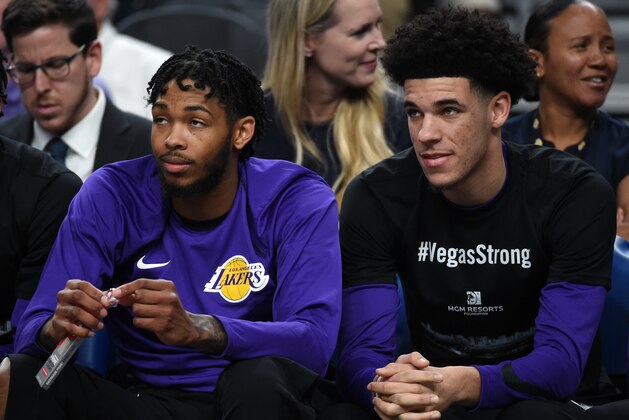 LAS VEGAS, NV - OCTOBER 08:  Brandon Ingram (L) #14 and Lonzo Ball #2 of the Los Angeles Lakers sit on the bench during their preseason game against the Sacramento Kings at T-Mobile Arena on October 8, 2017 in Las Vegas, Nevada. Ball wears a #VegasStrong T-shirt to honor victims of last Sunday's mass shooting. On October 1, Stephen Paddock killed at least 58 people and injured more than 450 after he opened fire on a large crowd at the Route 91 Harvest country music festival. The massacre is one of the deadliest mass shooting events in U.S. history. Los Angeles won 75-69. NOTE TO USER: User expressly acknowledges and agrees that, by downloading and or using this photograph, User is consenting to the terms and conditions of the Getty Images License Agreement.  (Photo by Ethan Miller/Getty Images)