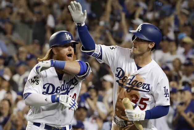 Los Angeles Dodgers' Justin Turner, left, celebrates his two-run home run with Cody Bellinger against the Houston Astros during the sixth inning of Game 1 of baseball's World Series Tuesday, Oct. 24, 2017, in Los Angeles. (AP Photo/Matt Slocum)