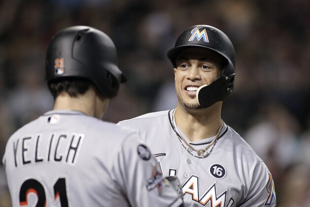 Miami Marlins' Giancarlo Stanton, right, talks with teammate Christian Yelich (21) in the on-deck circle as they wait to bat against the Arizona Diamondbacks during the sixth inning of a baseball game, Friday, Sept. 22, 2017, in Phoenix. The Diamondbacks defeated the Marlins 13-11. (AP Photo/Ralph Freso)
