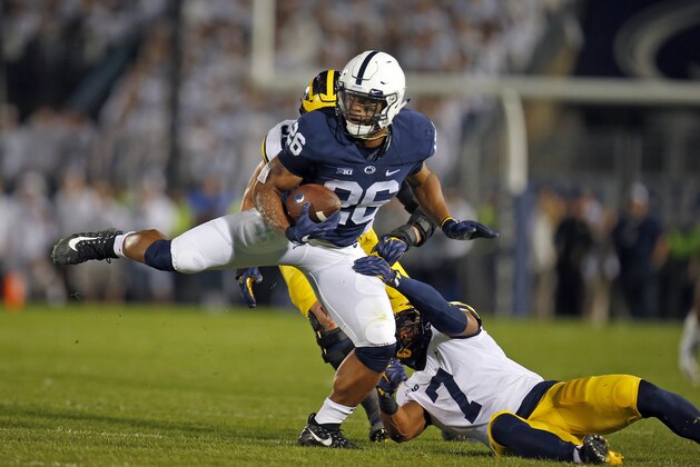 STATE COLLEGE, PA - OCTOBER 21:  Saquon Barkley #26 of the Penn State Nittany Lions runs after making a catch in the first half against Khaleke Hudson #7 and Noah Furbush #59 of the Michigan Wolverines on October 21, 2017 at Beaver Stadium in State College, Pennsylvania.  (Photo by Justin K. Aller/Getty Images)