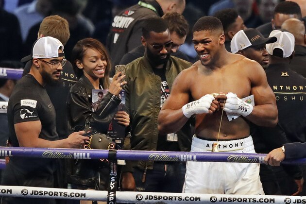 British boxer Anthony Joshua, right, smiles as he celebrates after beating Ukrainian boxer Wladimir Klitschko in a fight for Joshua's IBF and the vacant WBA Super World and IBO heavyweight titles at Wembley stadium in London, Saturday, April 29, 2017. Joshua won with an 11th round stoppage. (AP Photo/Matt Dunham)